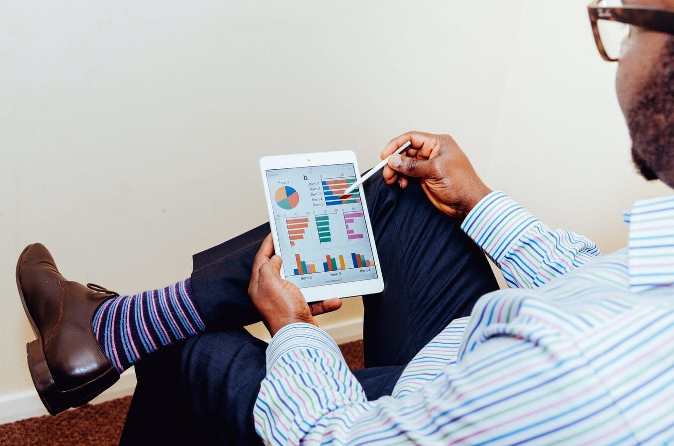 A man reviews some charts and graphs on an iPad
