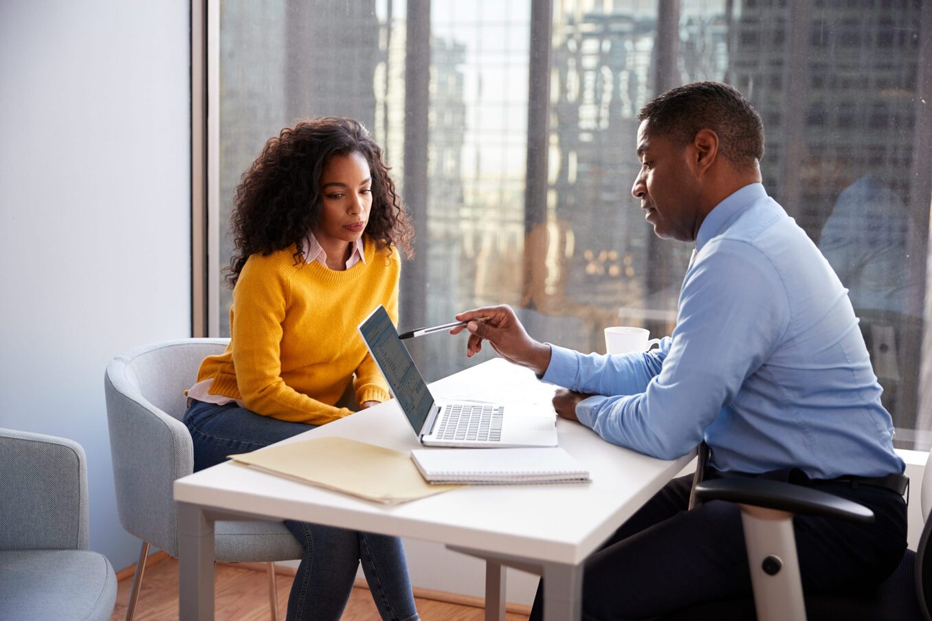 Woman Meeting With Male Financial Advisor Relationship Counsellor In Office