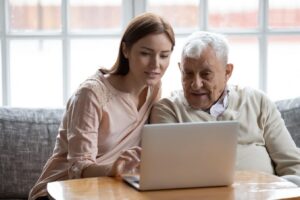 Young woman and grandfather researching 401(k) vs IRA