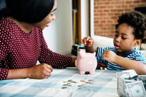 Mother teaching young kid about saving money