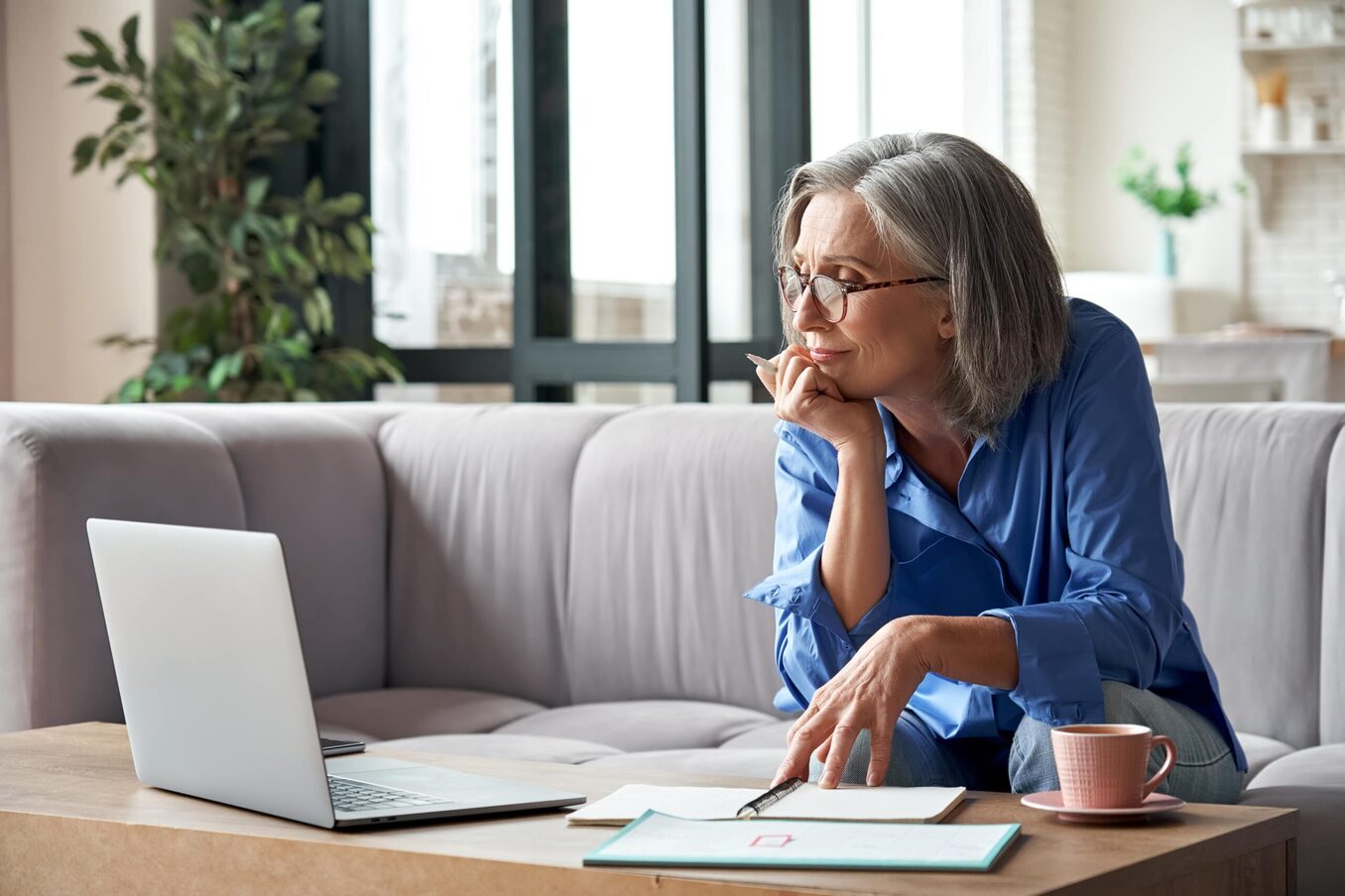 Senior woman reviewing financial documents at home
