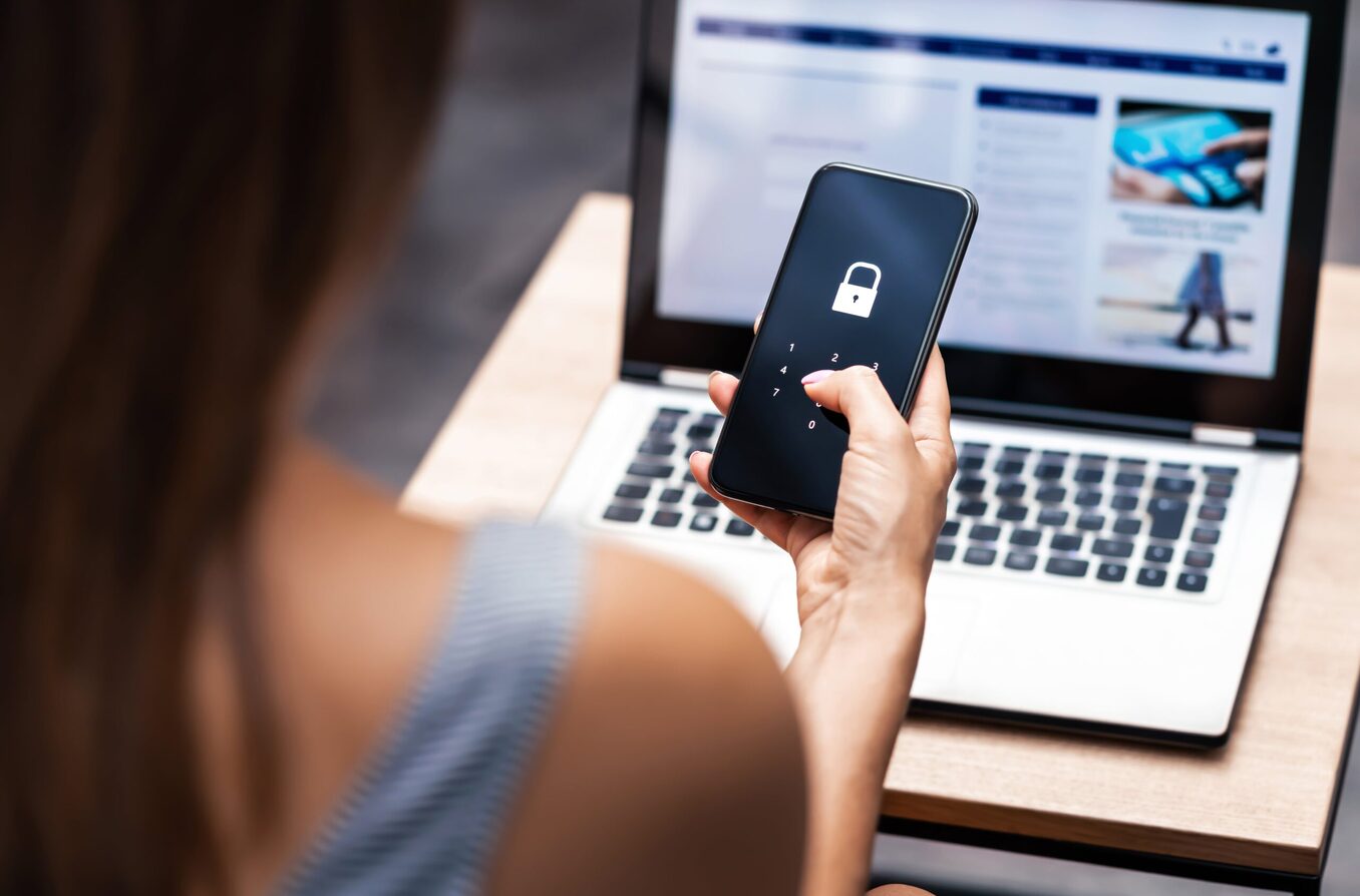 Close up of a woman holding phone and typing in security code