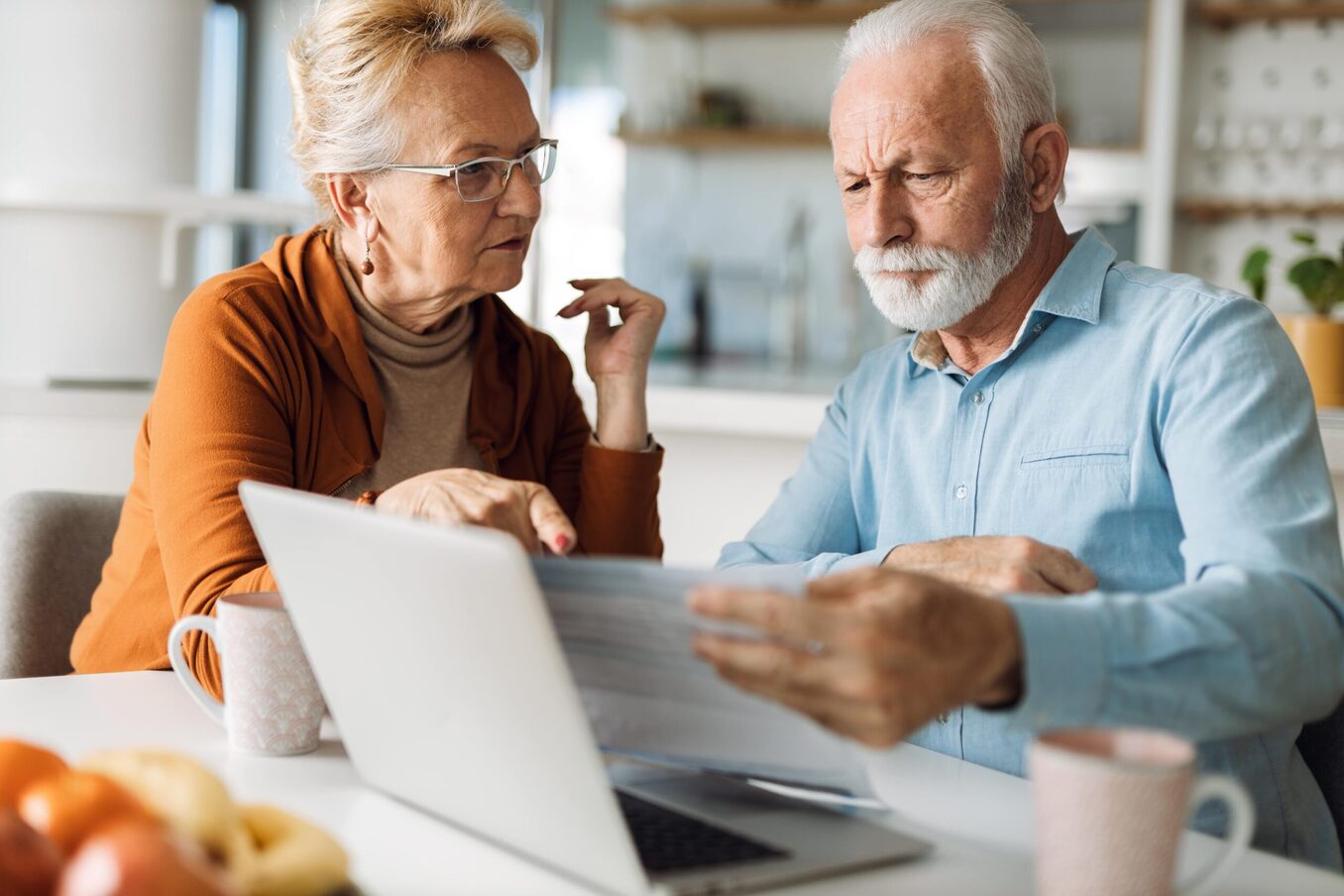 Elderly couple reviewing documents in front of a computer