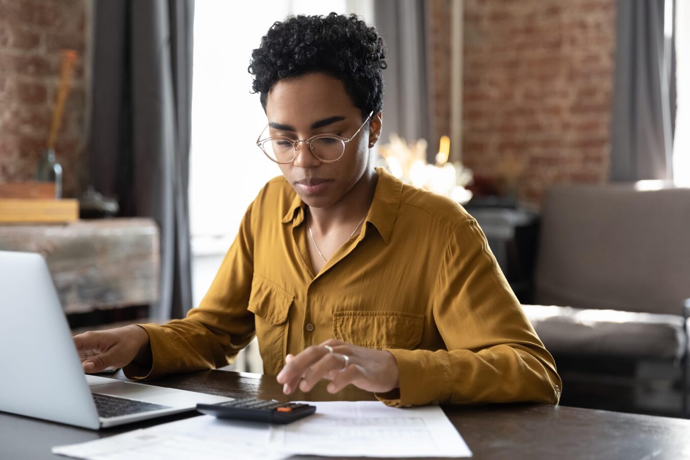 Woman doing calculations in front of laptop