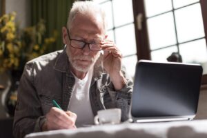 Old man writing in notebook