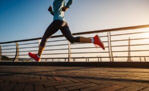 Healthy lifestyle woman runner running on seaside bridge