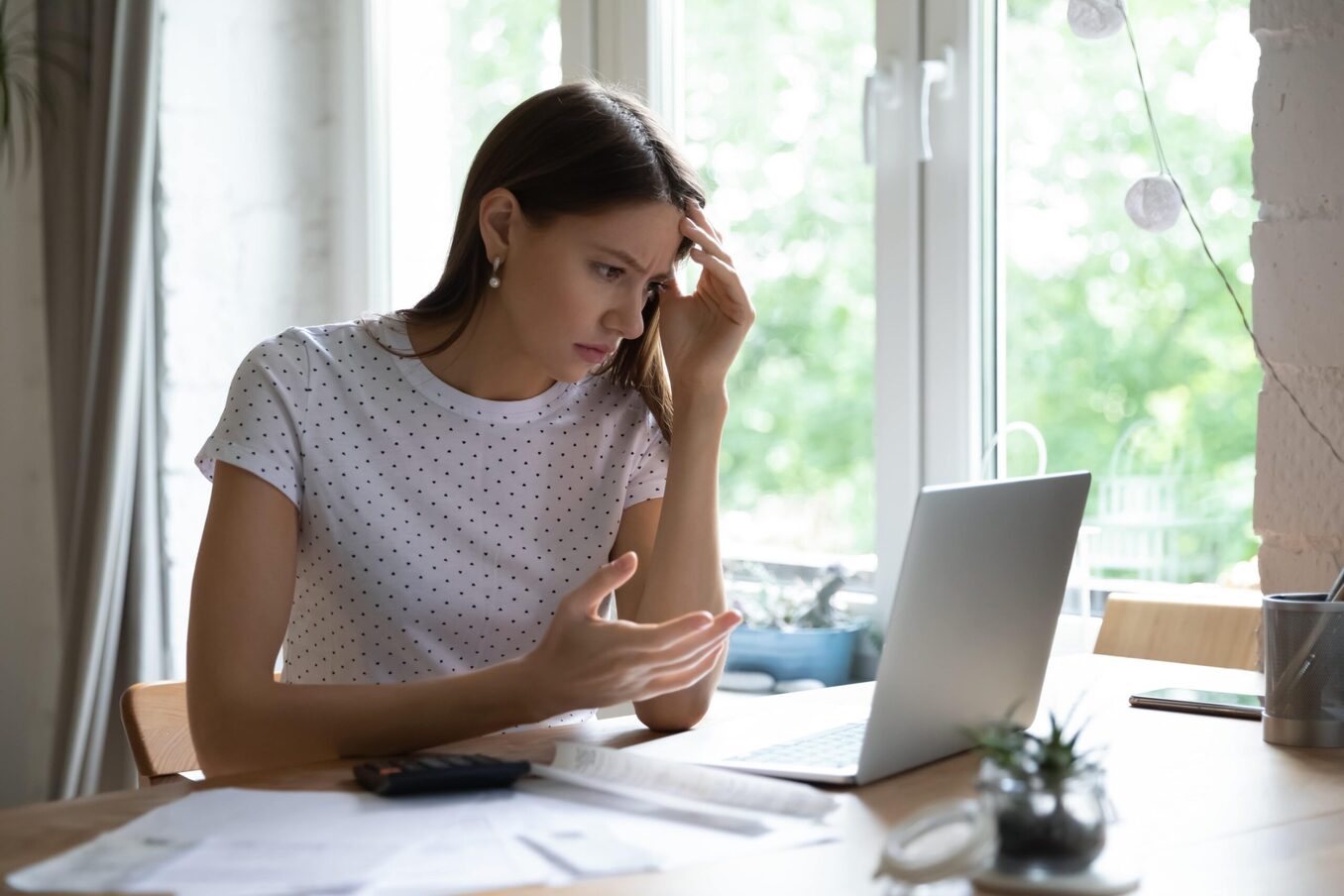 Woman using laptop looking confused