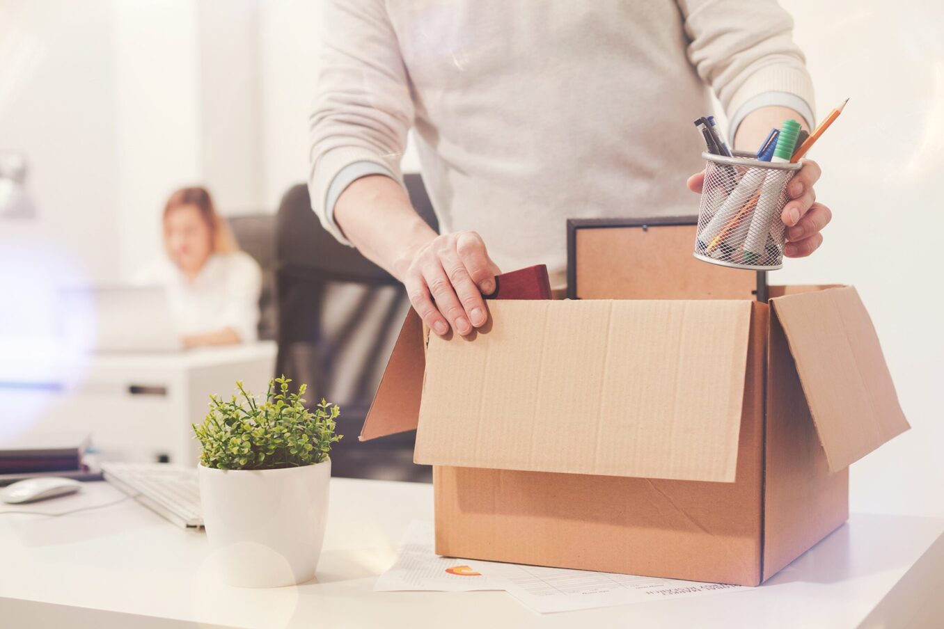 A man packing his belongings in a box in an office environment