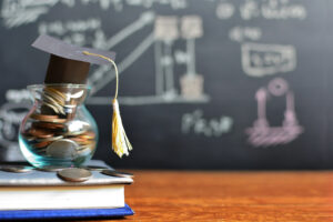 mortar board atop a jar filled with coins