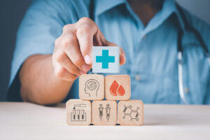 Doctor's hand stack woods block step on table with health care and medical icon