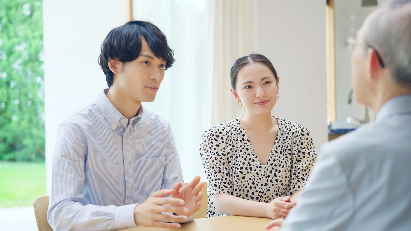 Young Asian couple talking with a senior man
