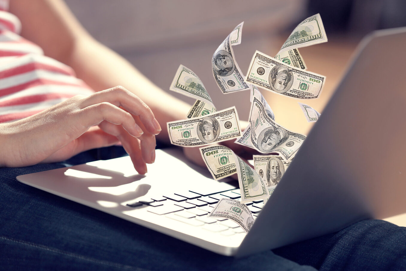Financial concept make money on the Internet. Woman sitting on couch with laptop open