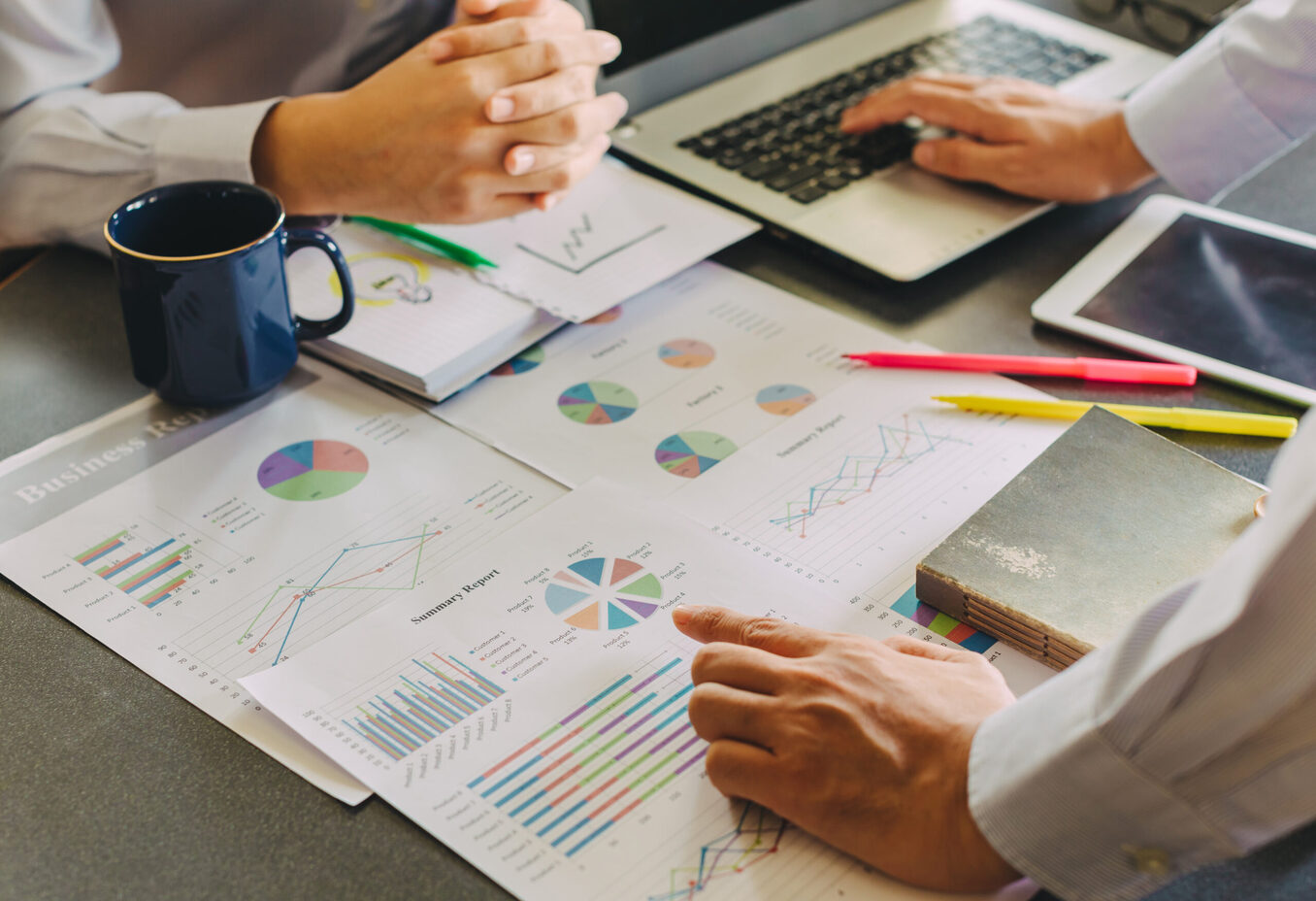 Two businessman investment consultant analyzing company financial report balance sheet statement working with documents graphs