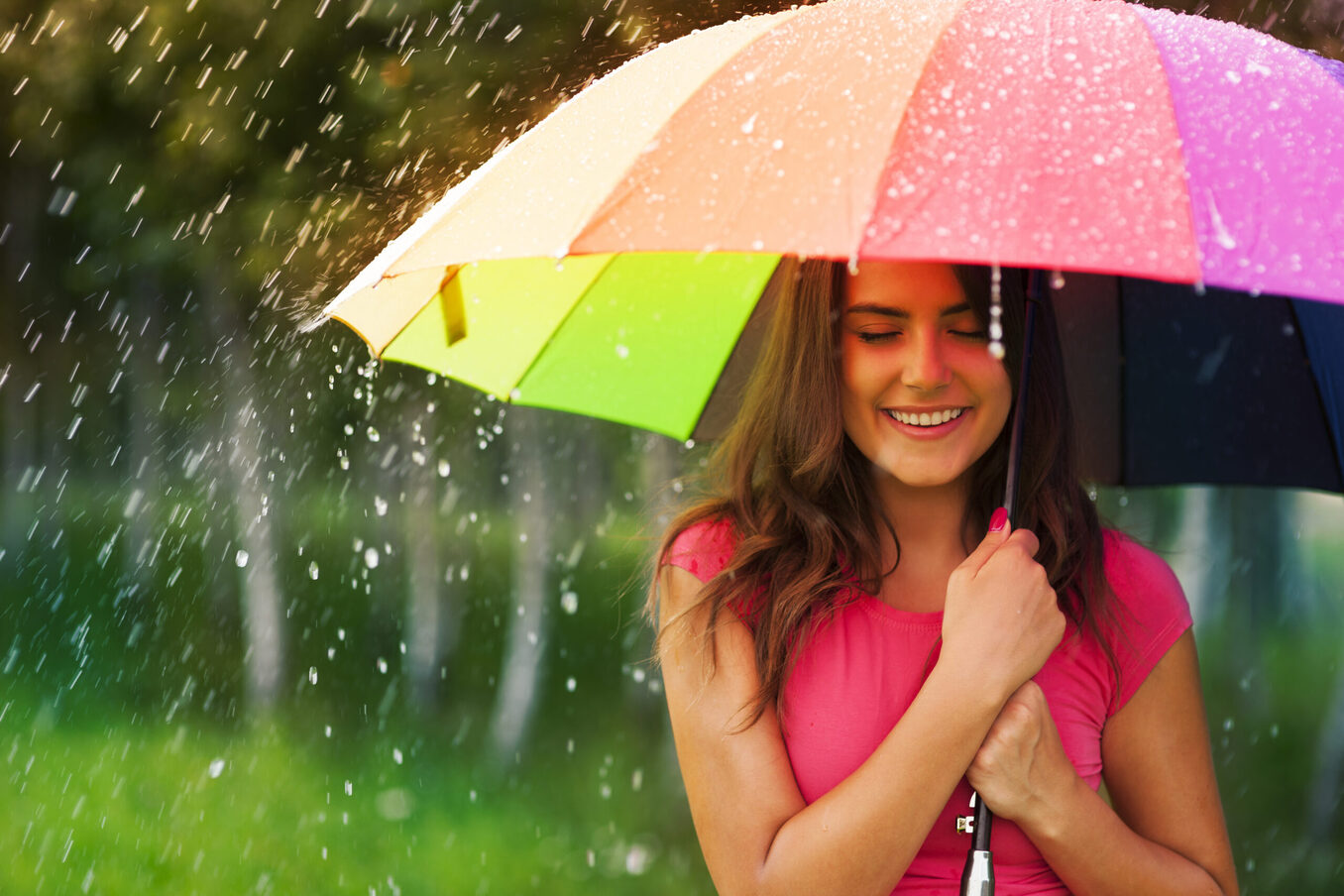 Woman under rainbow umbrella