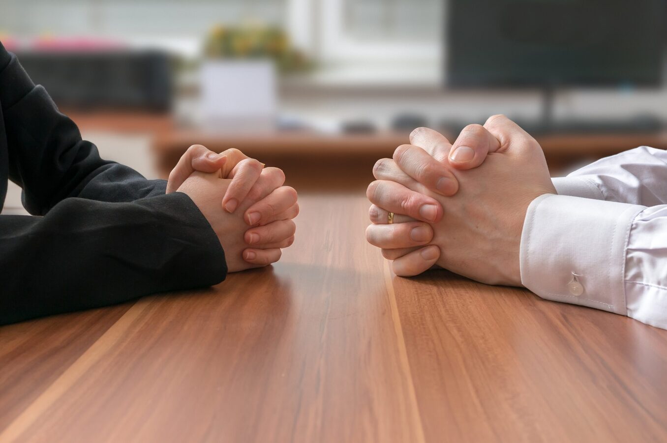 Negotiation of two people with clasped hands in office.