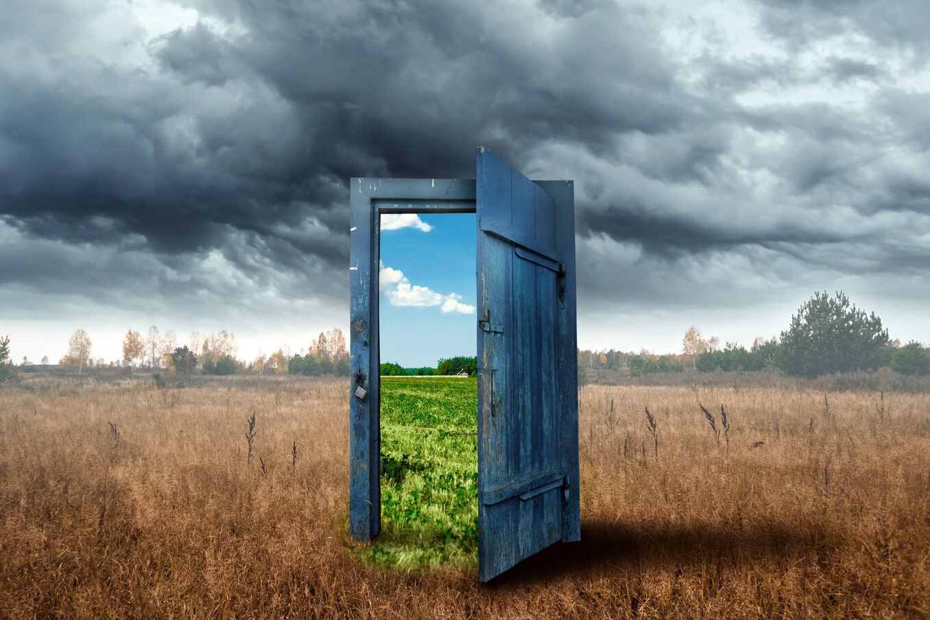 Creative background. Old wooden door, blue color, in the box. Transition to a different climate. The concept of climate change, portal, magic. Copy space.
