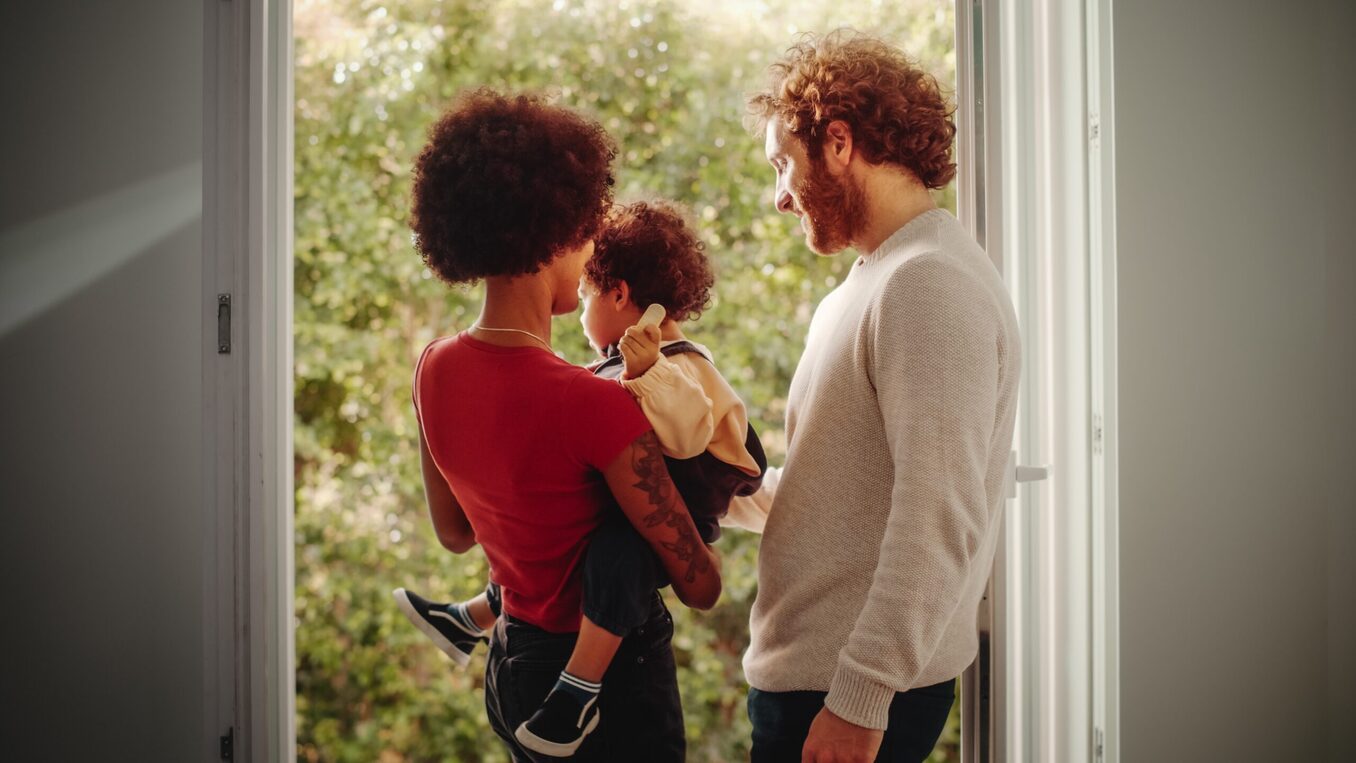 Loving Mixed Race Family Playing with Adorable Baby Boy at Modern Home, Holding Child. Cheerful Mother Nurturing a Child. Concept of Childhood, New Life, Parenthood.