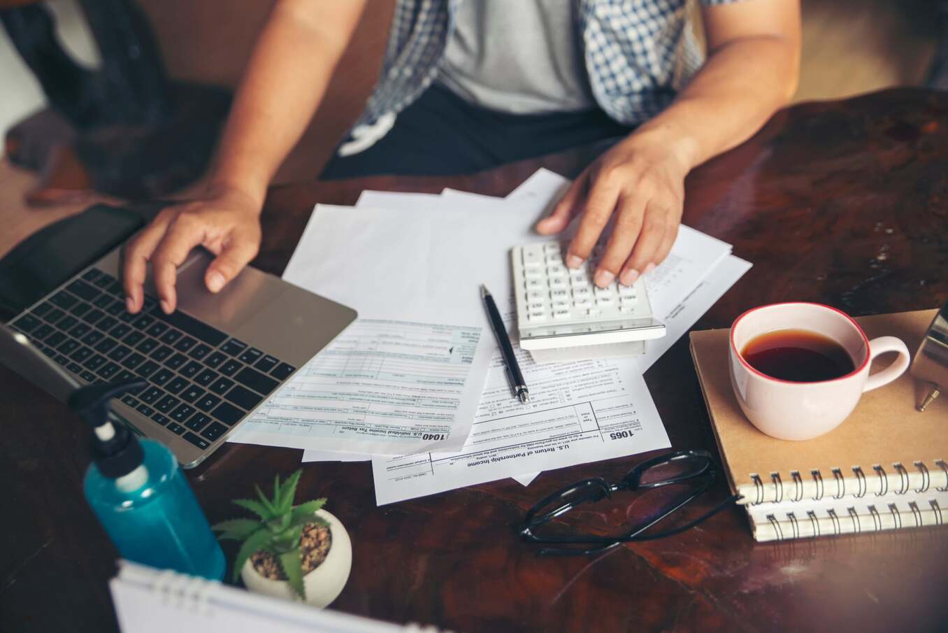 Man working on taxes and drinking tea on the side