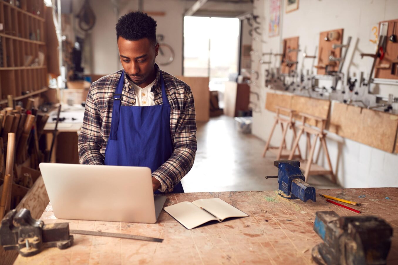 Man working on his laptop in a woodworking studio
