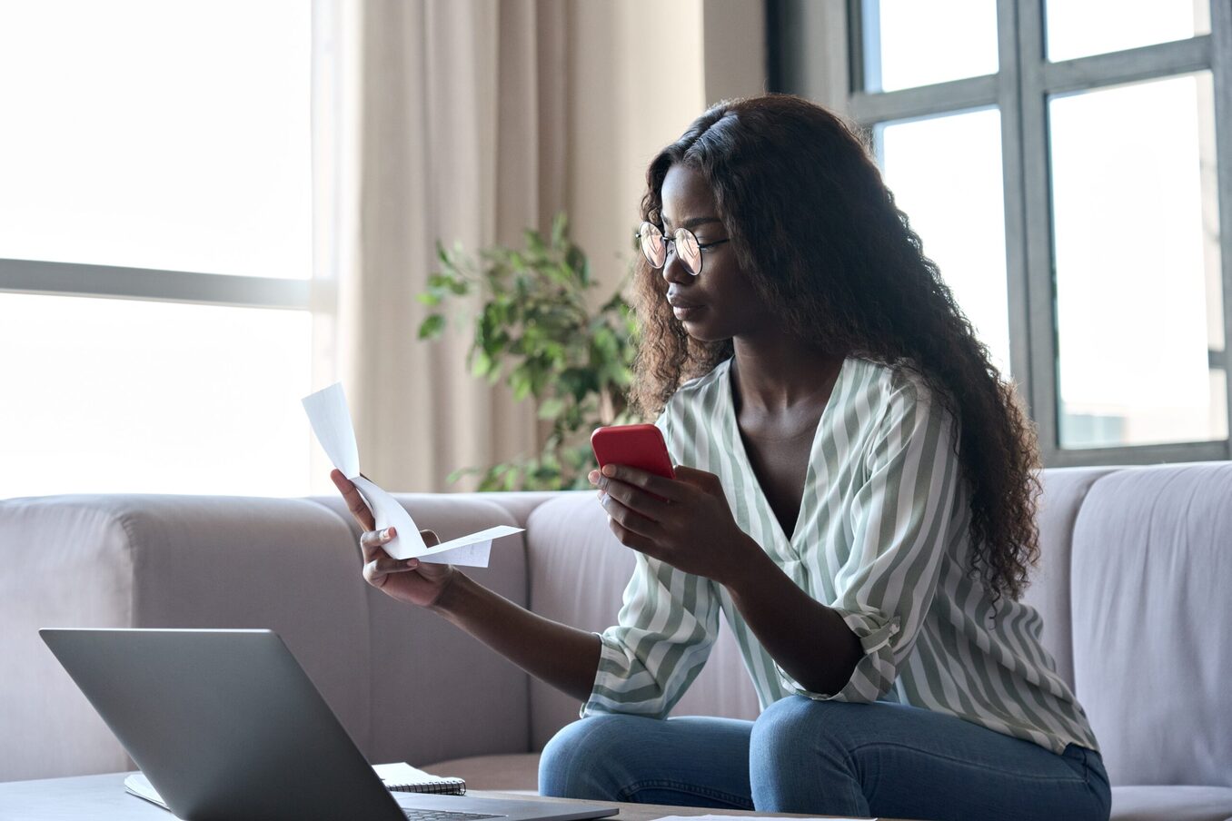 Serious young woman holding paper document calculating rent