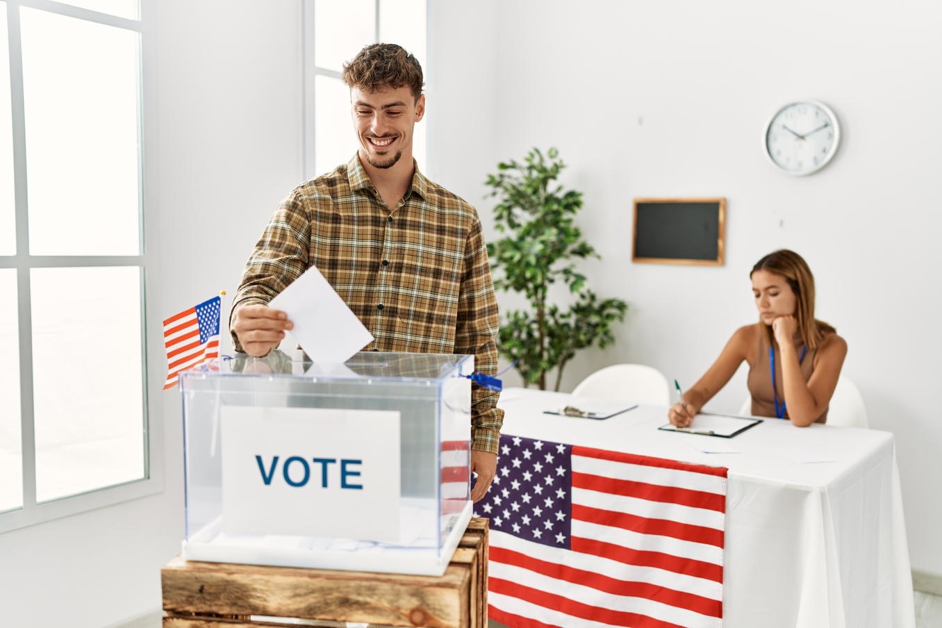 Young American voter putting vote in ballot box