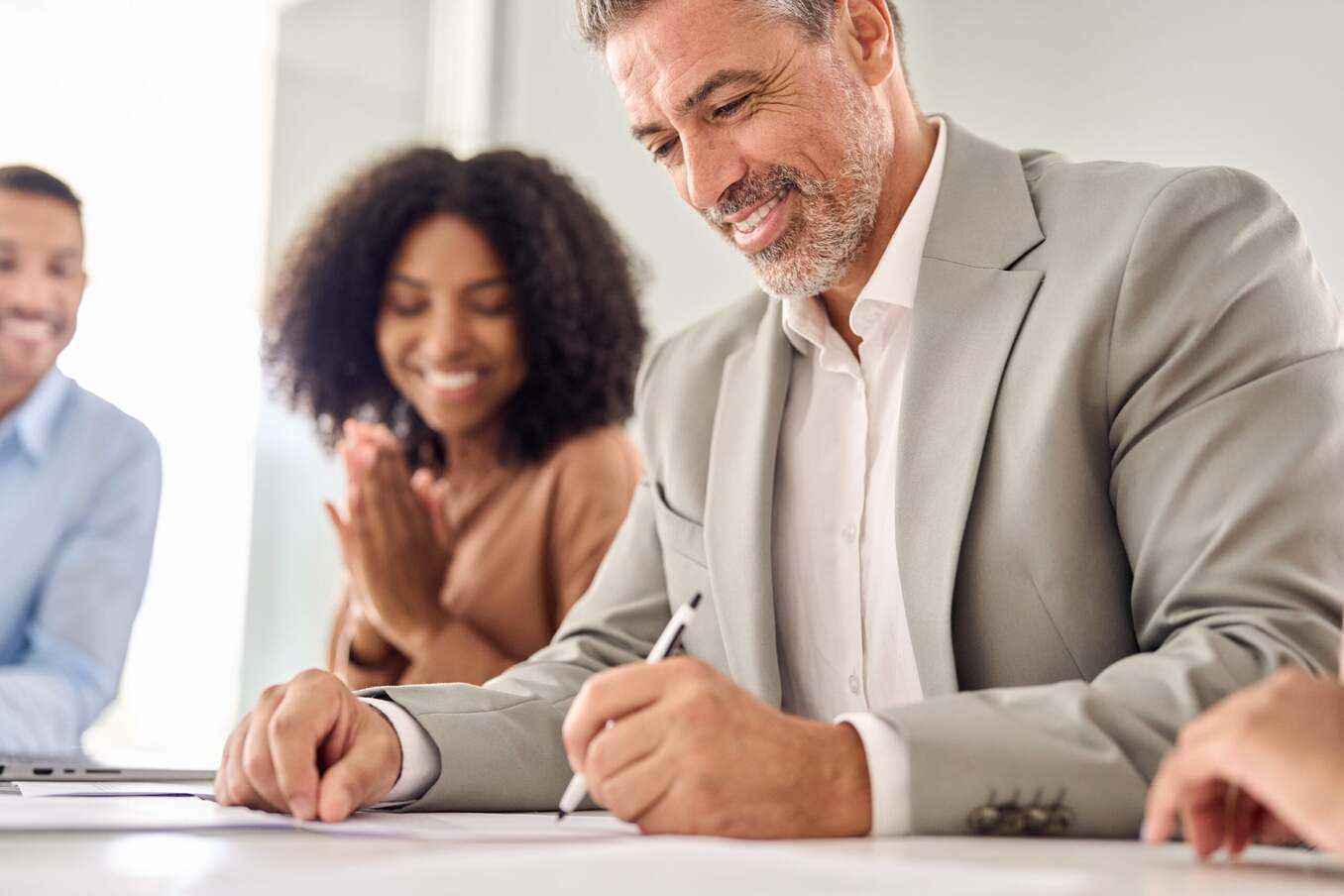 Man signing documents in a professional setting. Close up