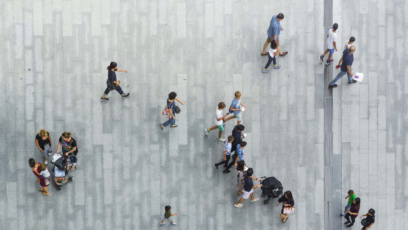 people walk on the pedestrian street walkway with the teenage young man and the group of family with little child. (Aerial urban city photo)