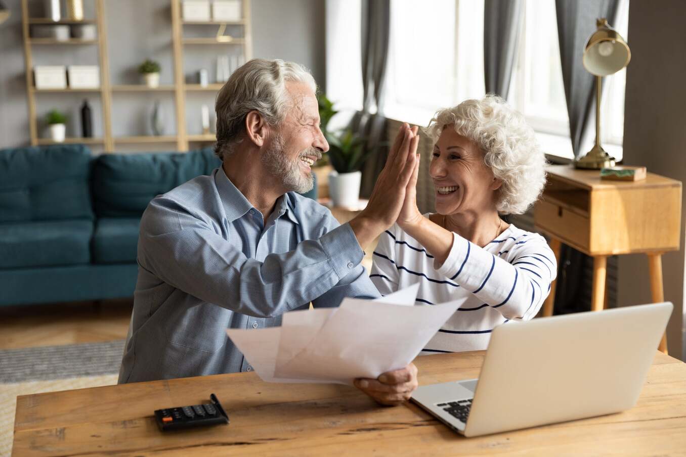 Middle aged married couple giving high five