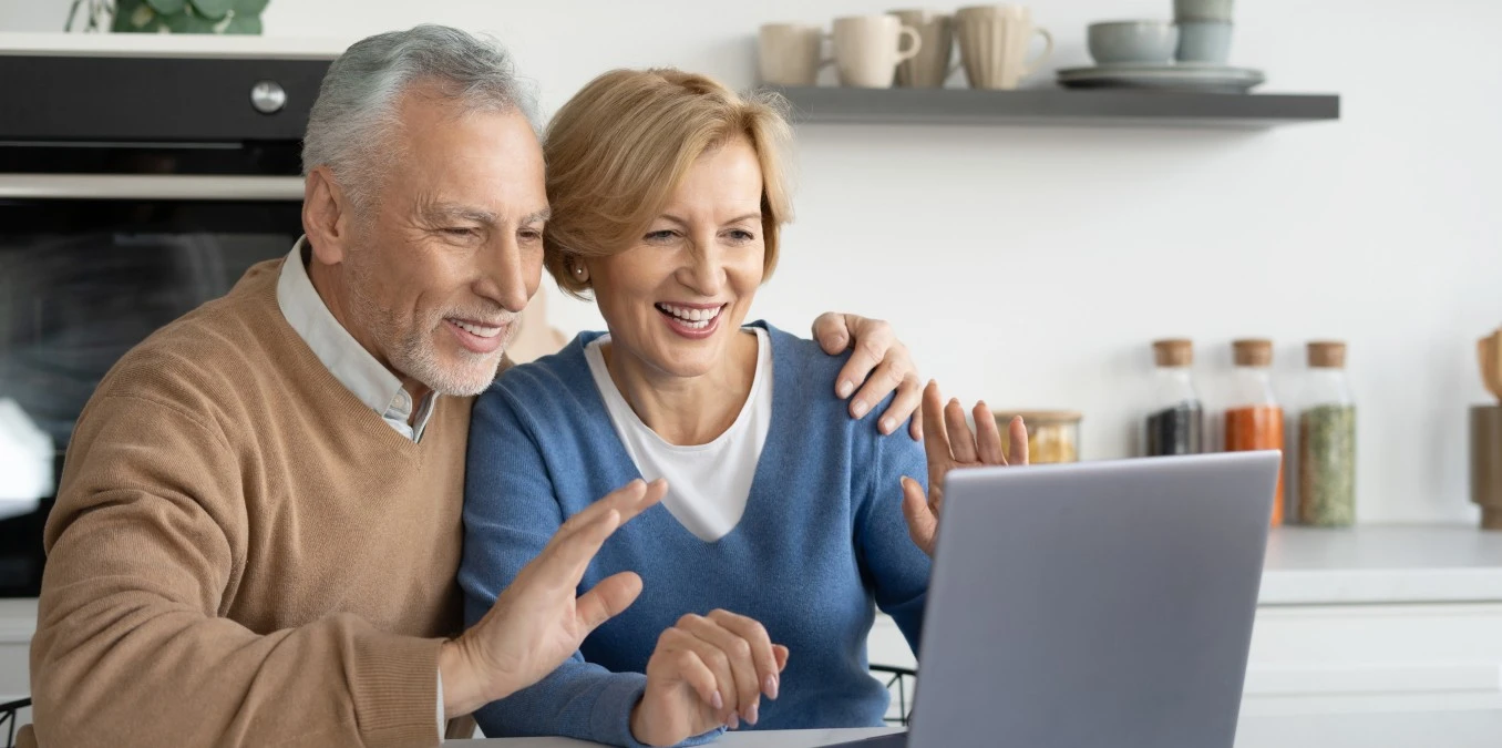 Mature married family couple making video call on laptop