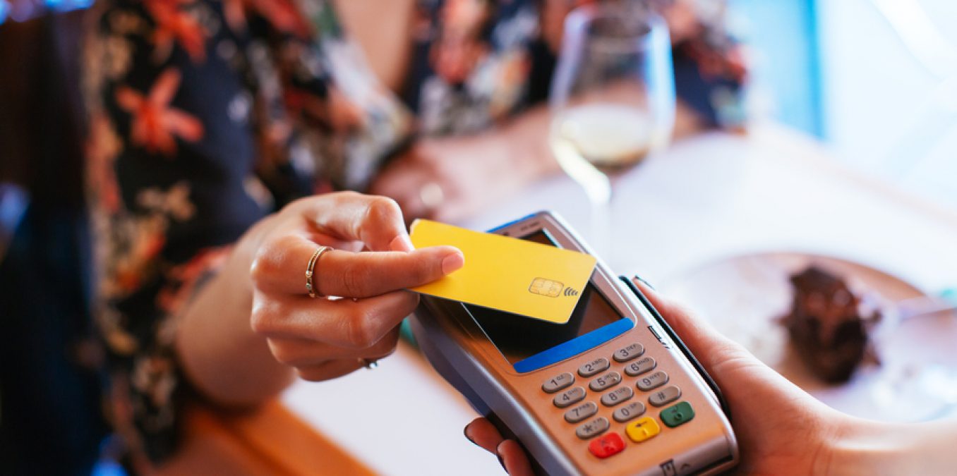 Close-up of a contactless credit card payment at a restaurant.
