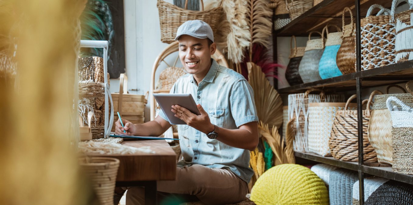 The,Shop,Owner,Notes,With,A,Pen,While,Using,A