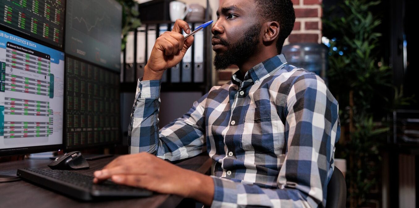 Brokerage company employee concentrated on forex stock market trend while following index marker. Investment agency data analyst thinking about risk free trading options.