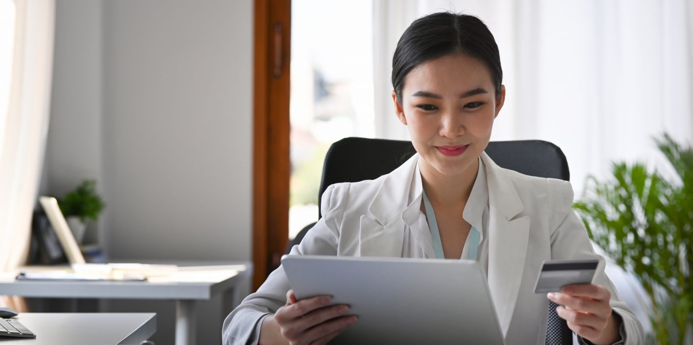 Attractive,Businesswoman,Holding,Credit,Card,And,Making,Banking,Online,With