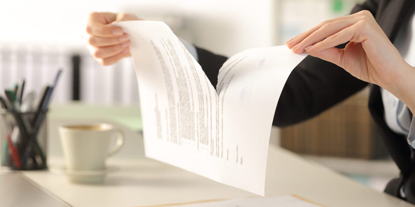 Close up of business woman hands breaking contract document sitting on a desk at the office