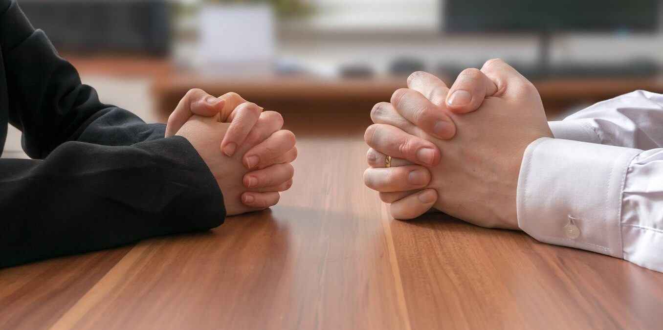 Negotiation of two people with clasped hands in office.