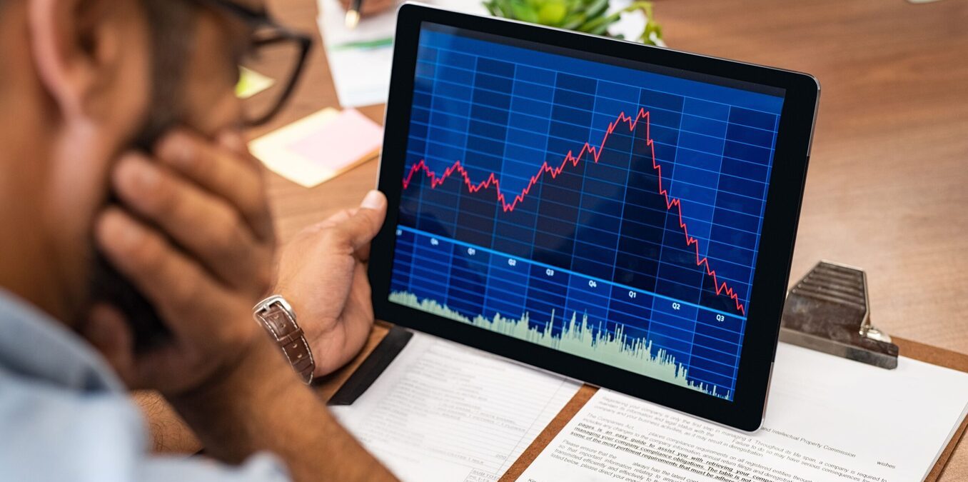 Man analyzing stock performance on a laptop