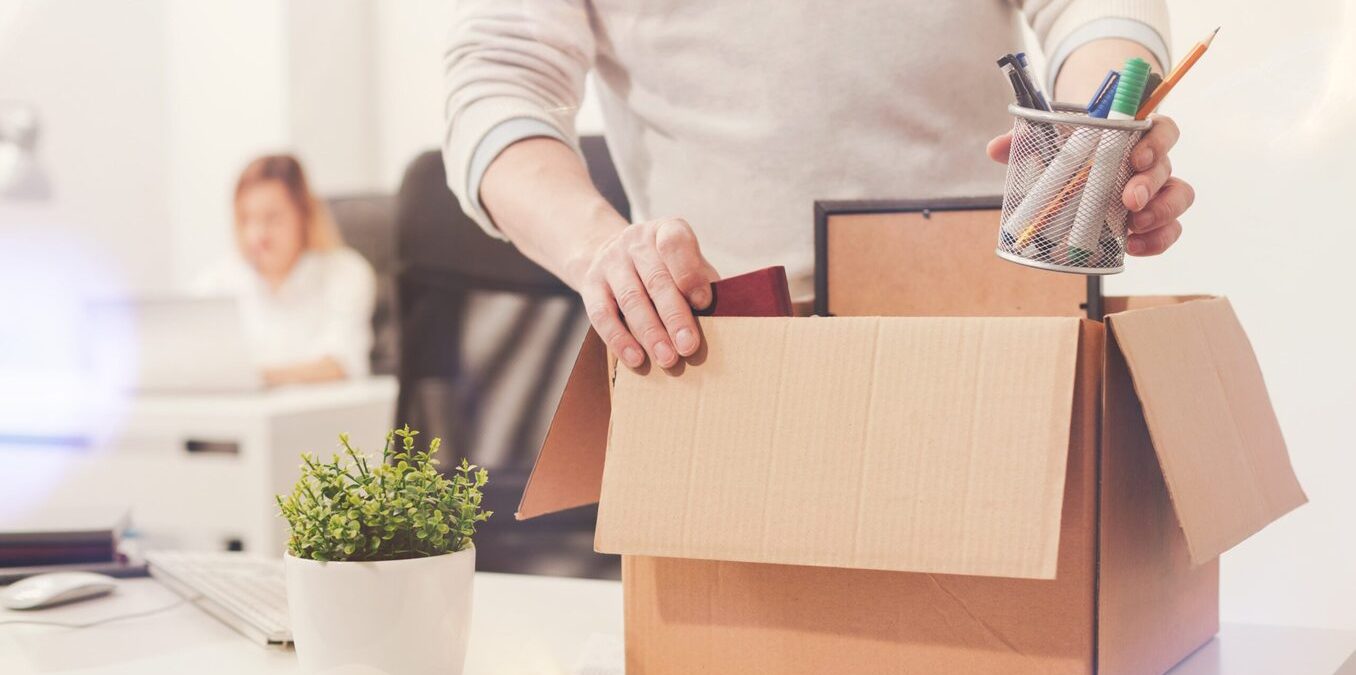 A man packing his belongings in a box in an office environment