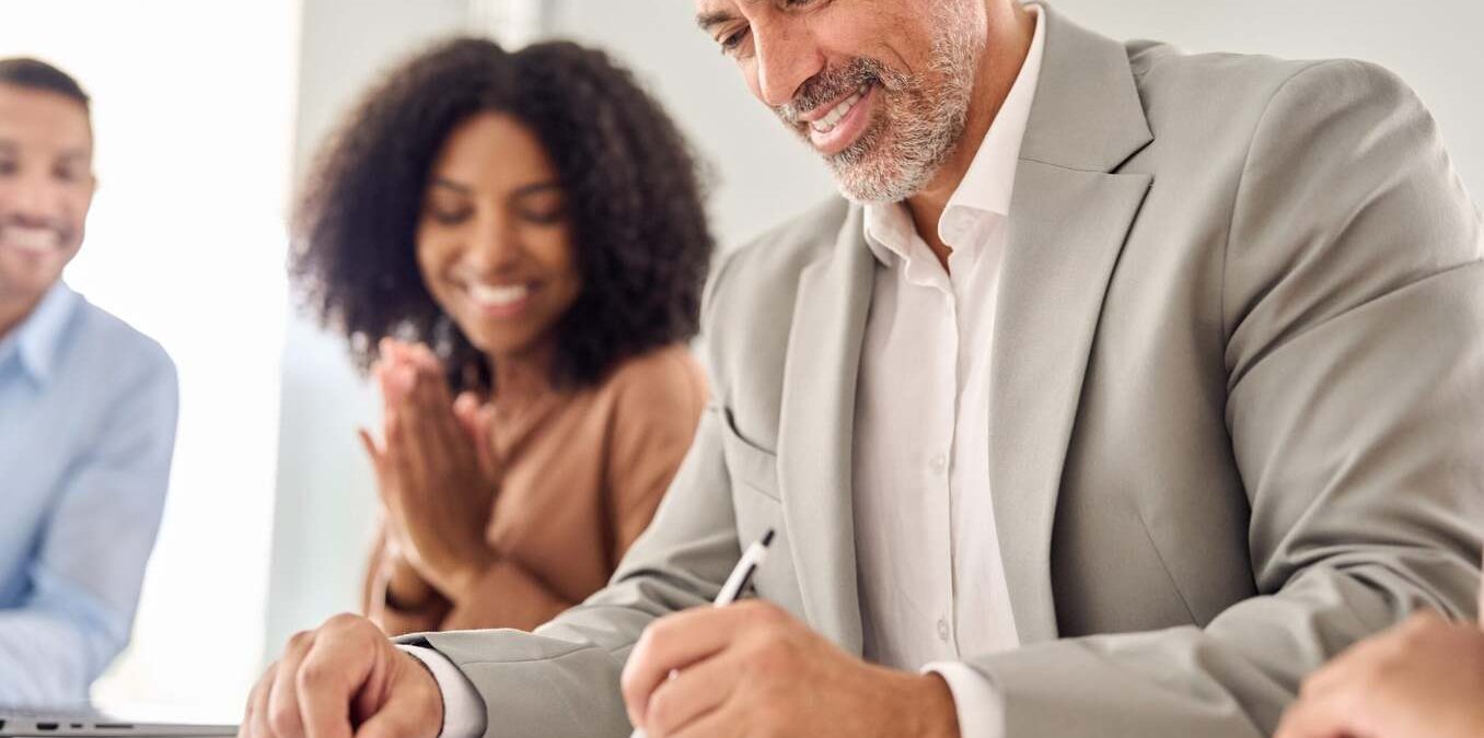 Man signing documents in a professional setting. Close up