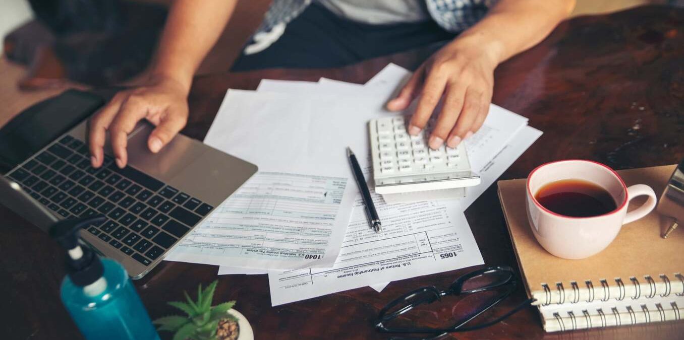 Man working on taxes and drinking tea on the side