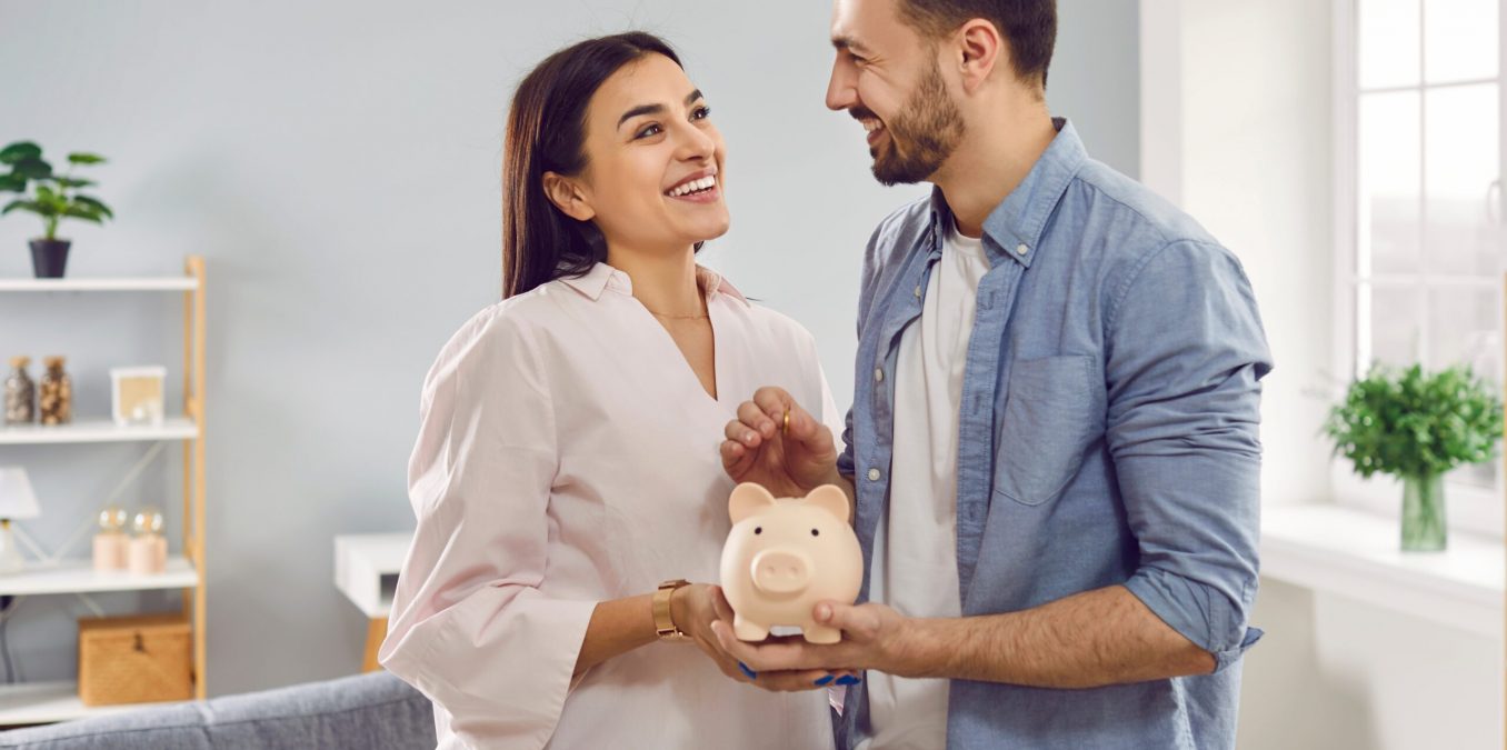Smiling,,Happy,Young,Family,Together,Put,Coins,In,Piggy,Bank