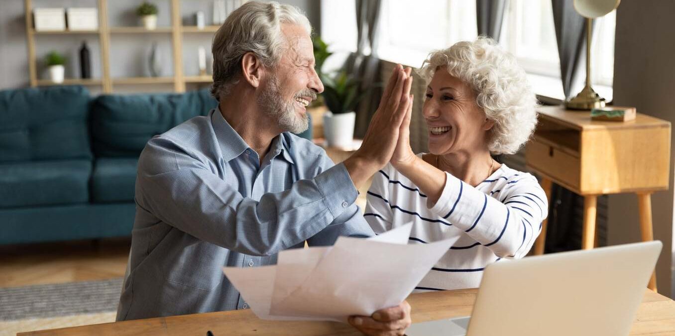 Middle aged married couple giving high five
