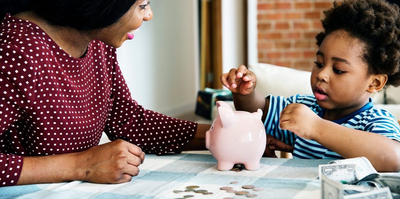 Mother teaching young kid about saving money