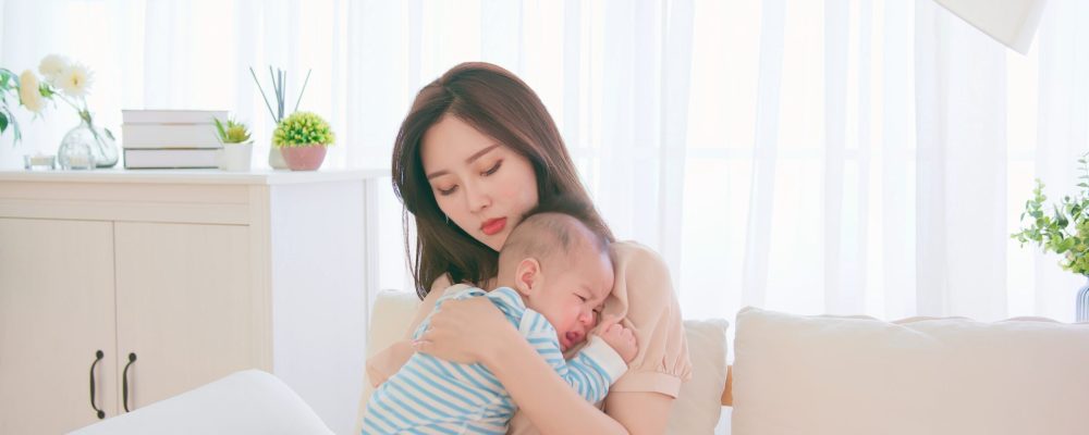 Authentic,Shot,Of,Asian,Mother,Holding,Her,Crying,Baby,On