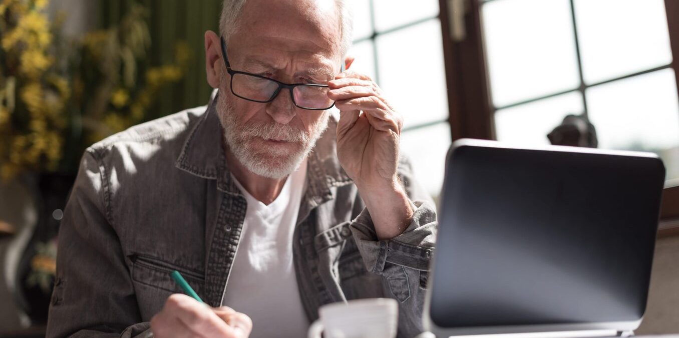 Old man writing in notebook