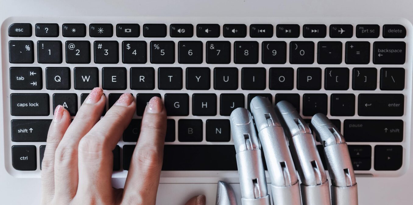 Robot hands and fingers point to laptop button advisor chatbot robotic artificial intelligence concept