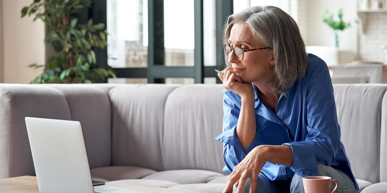 Senior woman reviewing financial documents at home