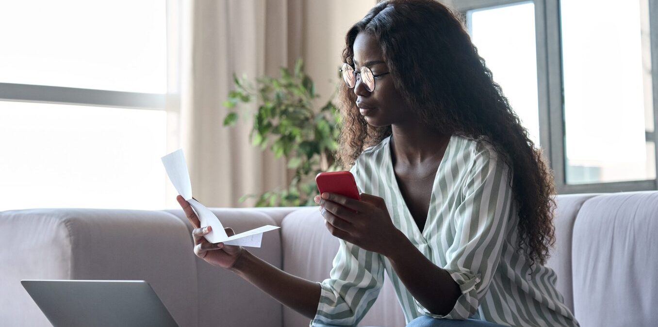 Serious young woman holding paper document calculating rent