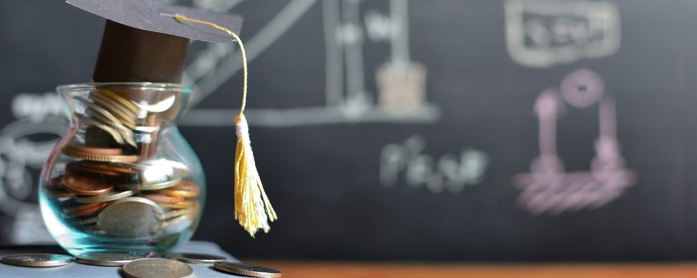 mortar board atop a jar filled with coins