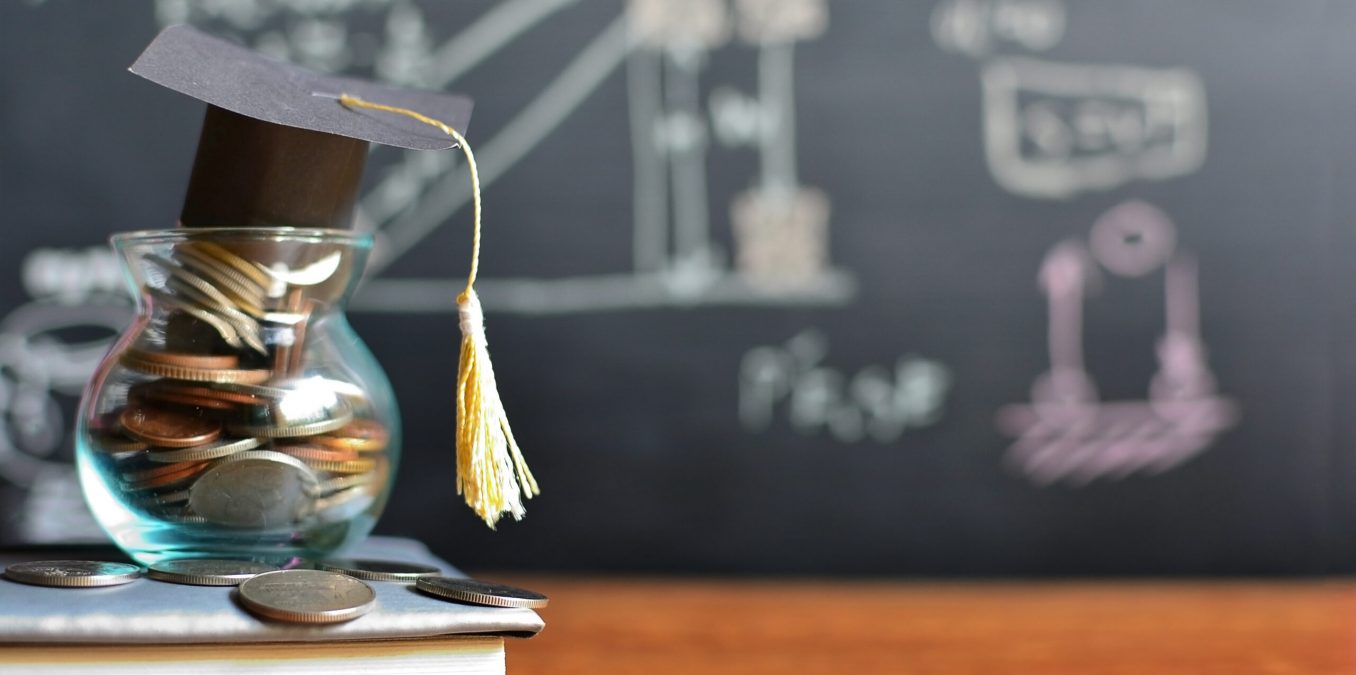 mortar board atop a jar filled with coins