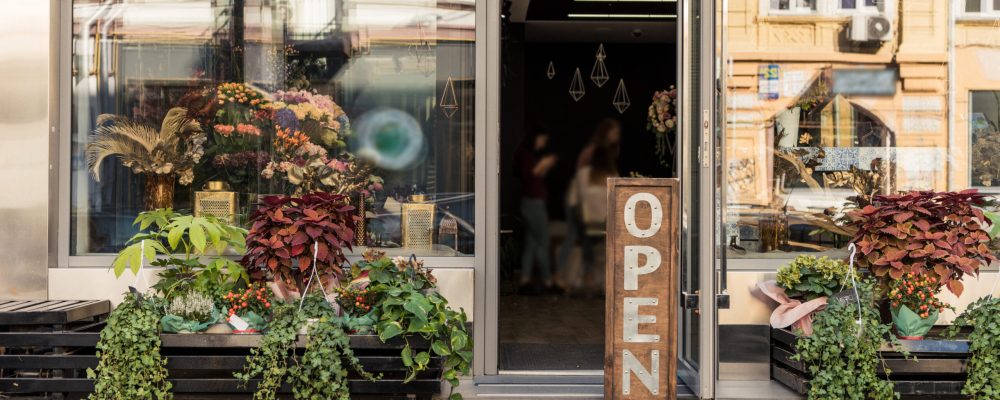 Open,Signboard,,Potted,Plants,And,Reflecting,Windows,At,Flower,Shop